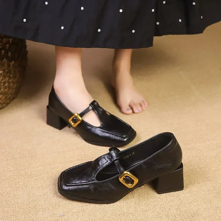 Elegant women's black Mary Janes, featuring a block heel, square toe, and sophisticated T-strap design.