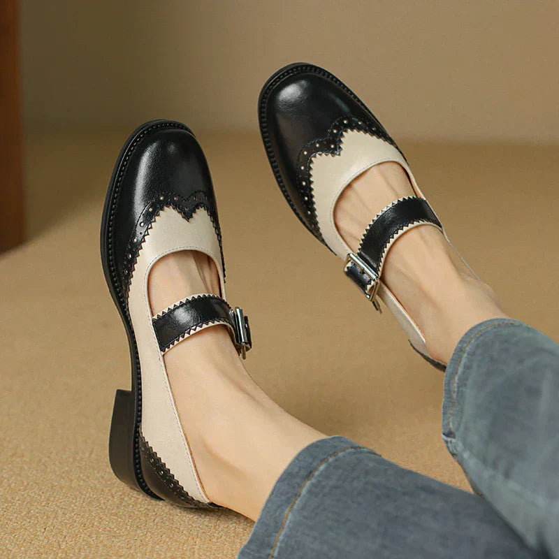 Women's black leather Mary Jane shoes with adjustable strap, flat sole, and round toe for casual wear.