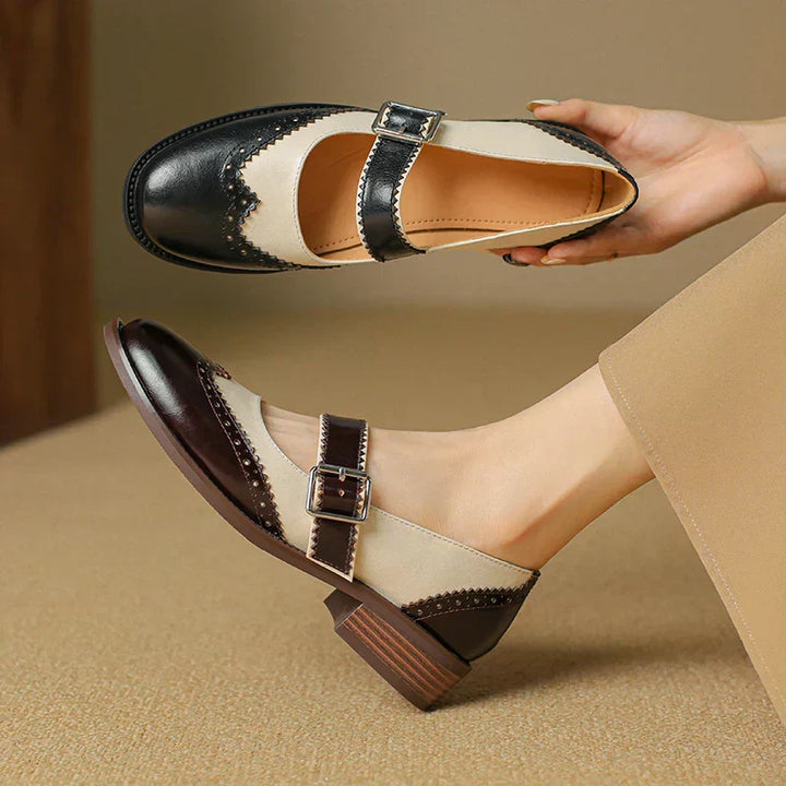 Front view of women's flat leather Mary Jane shoes with an elegant round toe and adjustable top strap in black.
