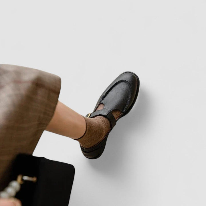 View of the low heel on a women's black leather orthopedic Mary Jane shoe with square toe