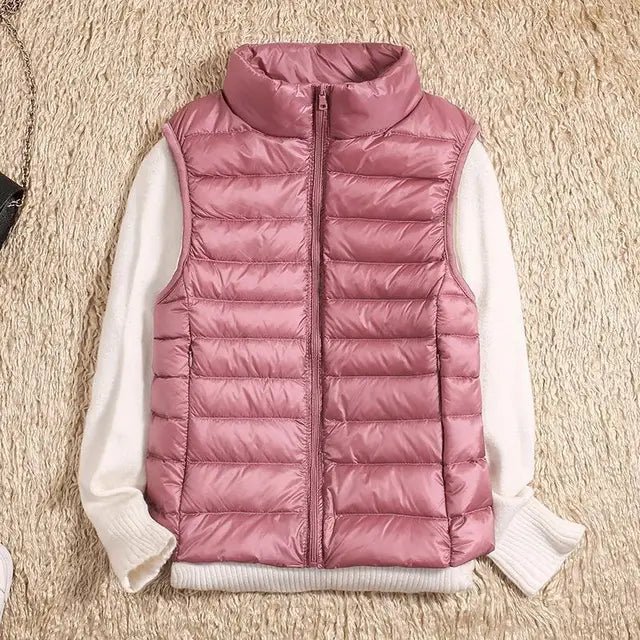 Model wearing a gray women's lightweight puffer vest over a long-sleeve shirt, ready for adventure.
