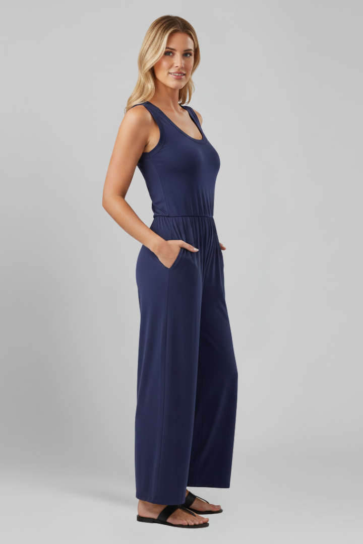 Model smiling in a front view of a comfortable pink round neck wide leg jumpsuit, one-piece outfit