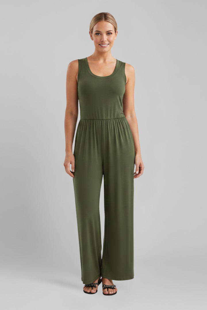 Woman sitting elegantly in a beige round neck wide leg jumpsuit, highlighting its flowy design