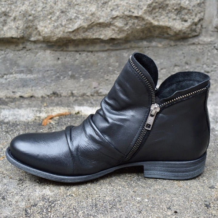 Women's black ruched leather ankle boots with side zipper, perfect for fall fashion.