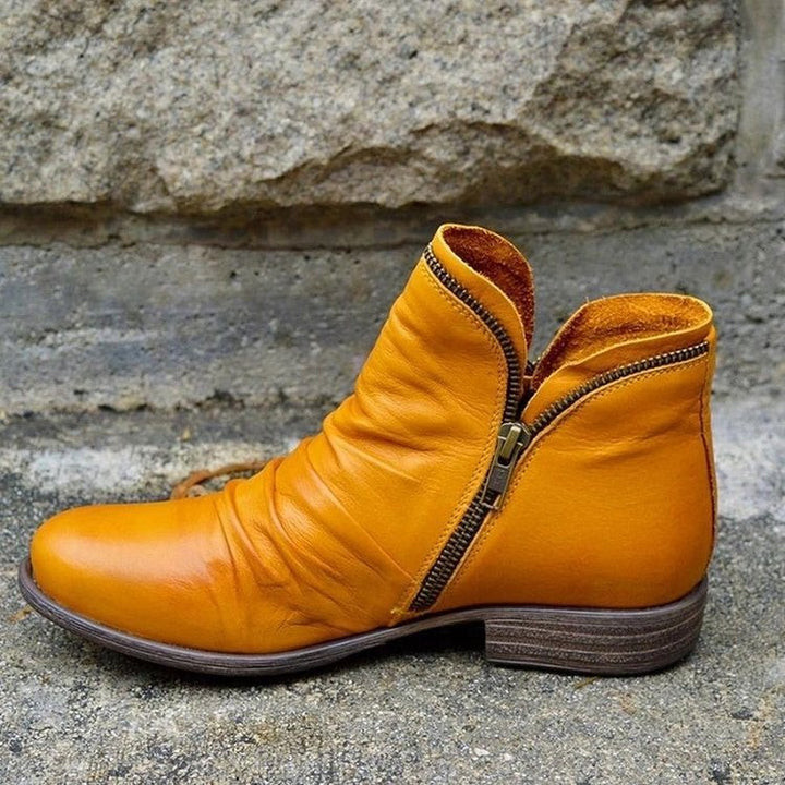 Stylish women's leather ankle boots featuring ruched detail and convenient side zipper.