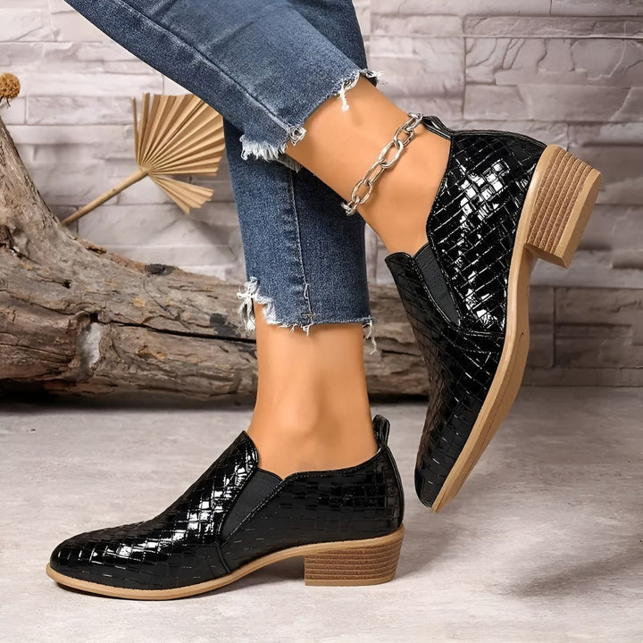 Pair of classic black oxford flats for women, made from comfortable vegan leather, ideal for work.