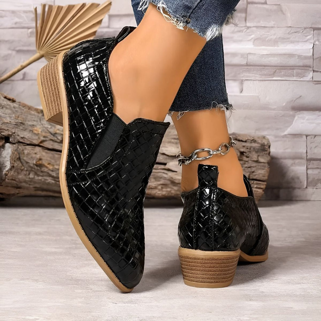 Close-up of women's comfort oxford shoe in black vegan leather, showcasing stitch details.