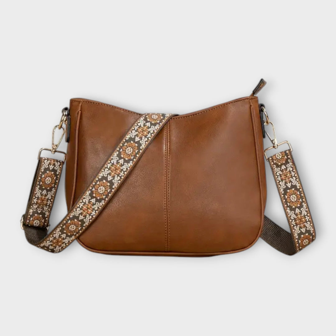 Women's boho crossbody bag in vegan leather with intricate patterned strap, ideal for casual everyday wear.
