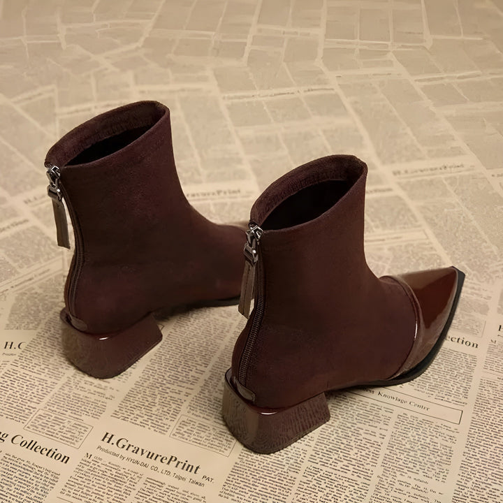 Woman walking outdoors wearing brown block heel ankle boots, showcasing versatility.