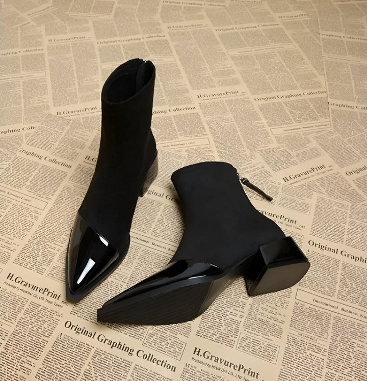 Detail shot of the block heel on a women's black ankle boot, emphasizing stability.