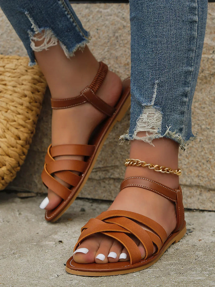 Casual open-toe women's flat sandals with cross straps & elastic heel for comfortable summer wear.