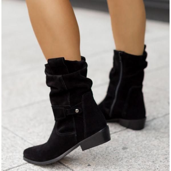 Pair of new women's comfortable suede Western ankle boots on a wooden floor.