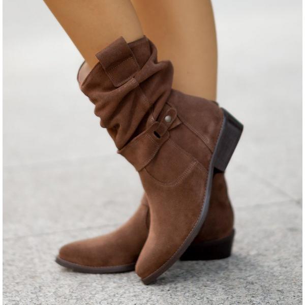 Model wearing women's black suede Western ankle boots, street style shot.