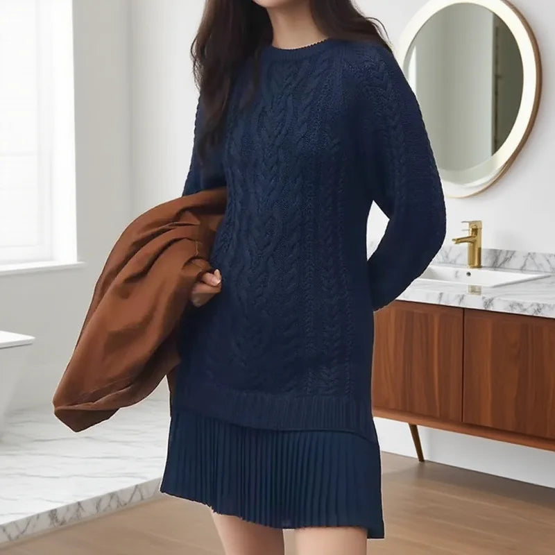 Front view of women's cable knit sweater dress, showcasing the pleated hem and long sleeves.