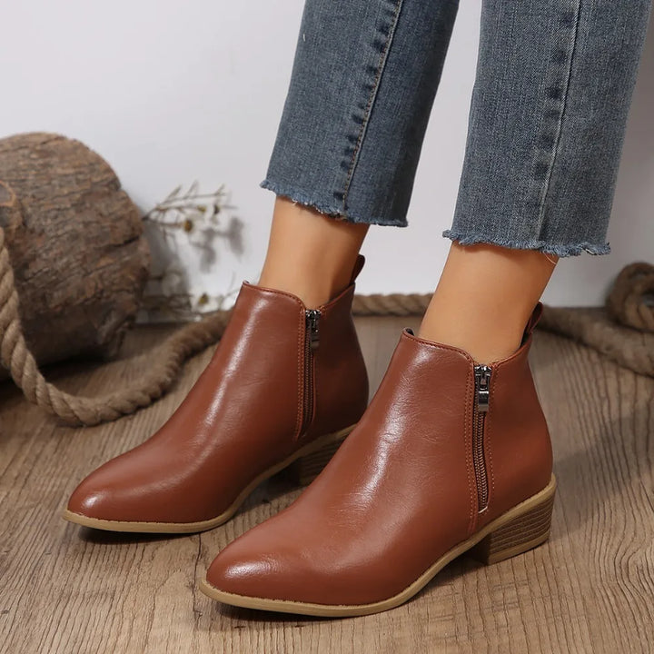 Stylish black women's ankle boots with a functional side zip, ideal for versatile casual outfits.