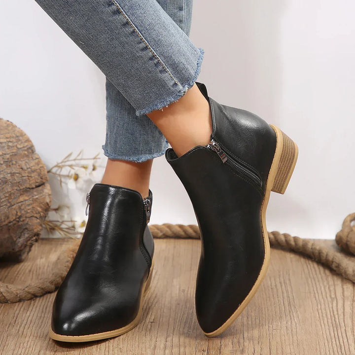 Pair of women's trendy ankle boots positioned for a look at the side zip closure and casual design.