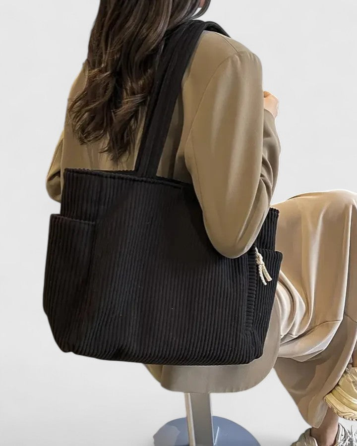Close-up of the women's utility shoulder bag texture, highlighting the canvas fabric and stitching