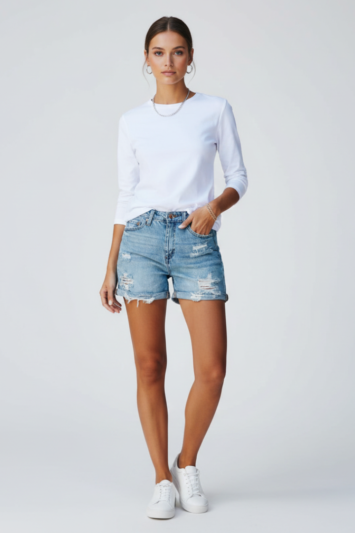Fashionable women's denim shorts featuring a distressed look and a trendy fringe hem.