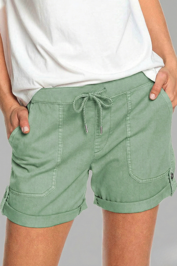 Pair of women's white drawstring shorts on a hanger, ready for a warm weather outfit.