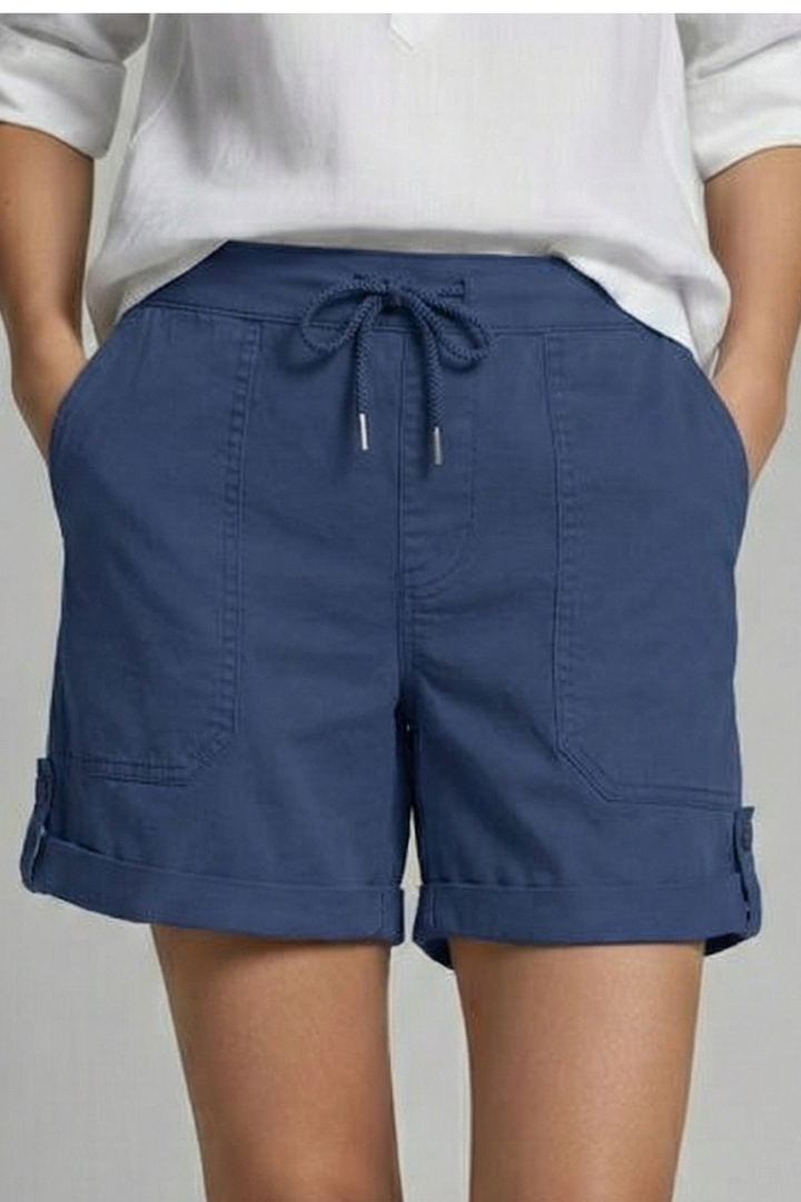 Model walking outdoors wearing stylish women's pocket shorts, showing movement and fit.