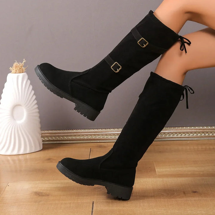 Fashionable women's buckle-accented suede long boots, suitable for everyday winter wear.