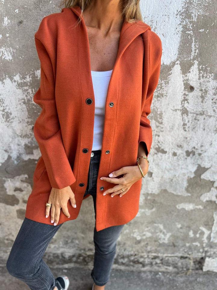 Front view of a women's knit hoodie jacket with prominent buttons, emphasizing its cozy texture and design.