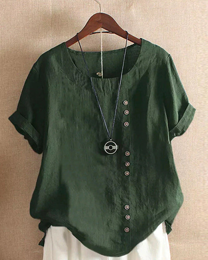 Side view of a women's short sleeve blouse, showcasing its relaxed fit and button embellishments