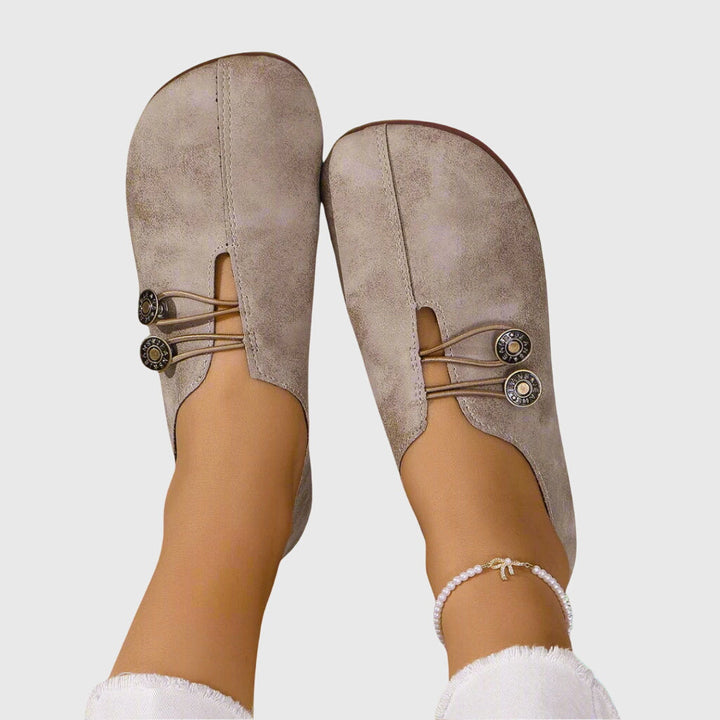 Close-up of a women's slip-on flat shoe, showcasing button detail and comfortable design