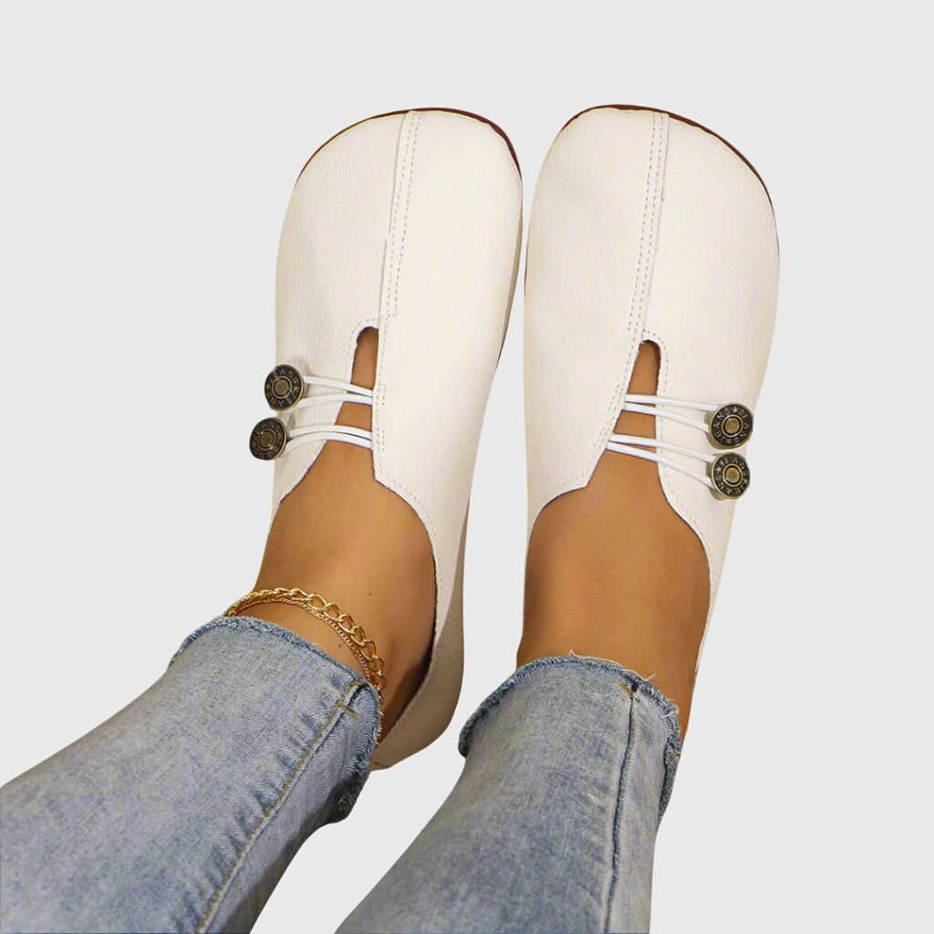 Women's footwear: light-colored slip-on flats with subtle button detail, great for warm weather