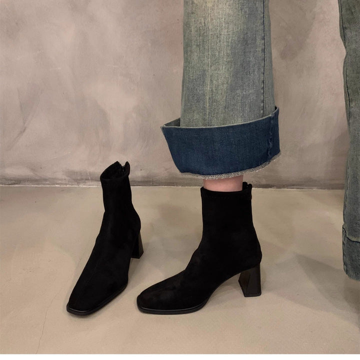 Stylish women's black ankle boots featuring a chic block heel and elegant pointed toe. Comfortable everyday fashion.