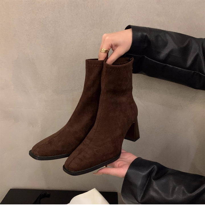 Modern women's black ankle boots. Chic block heel, pointed toe, and sleek design perfect for contemporary fashion.