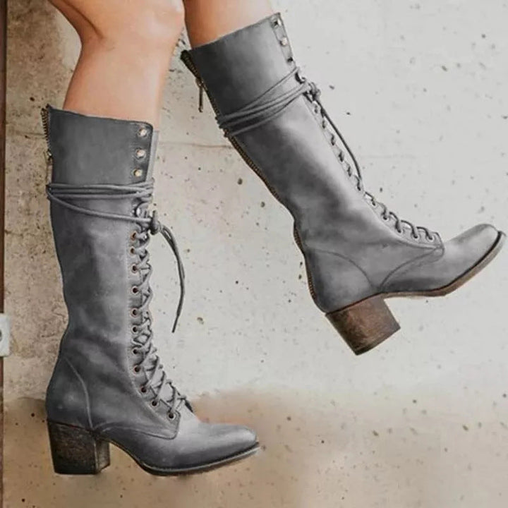 Stylish women's knee-high lace-up leather boots in black, ideal for an autumn chic look.