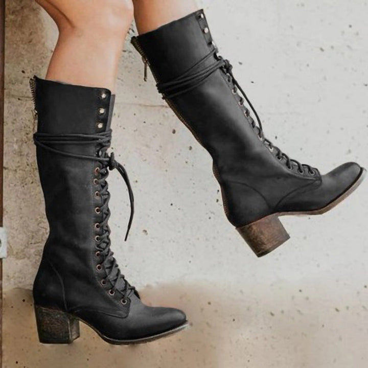 Pair of womens fashionable black leather lace-up tall boots, showcasing their sleek design.