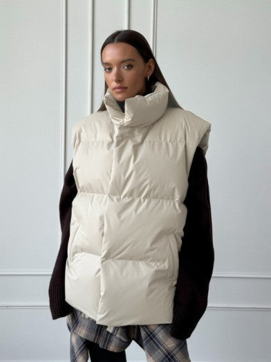 Cozy women's sleeveless puffer vest in a neutral color, ideal for trendy winter fashion & versatile layering.