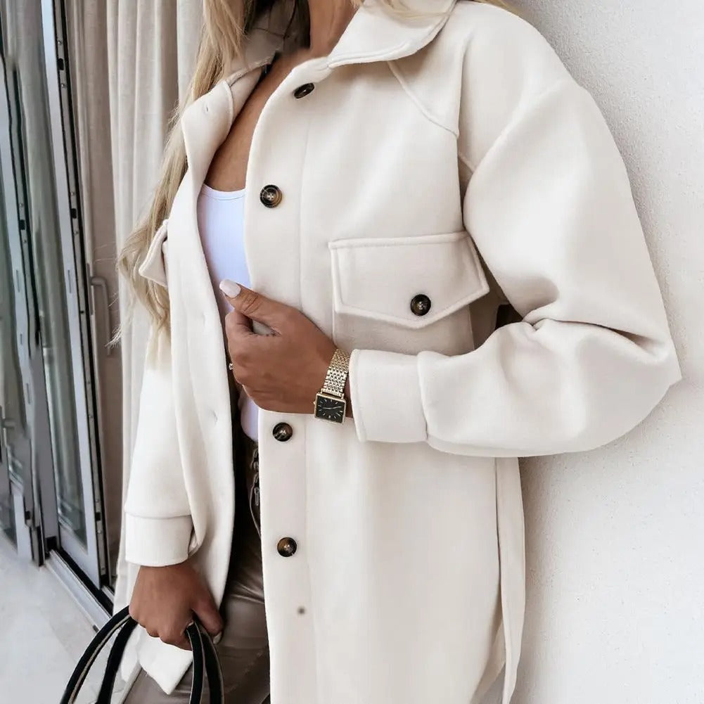 Close-up of a women's chic oversized jacket, showing soft wool blend texture and button detail