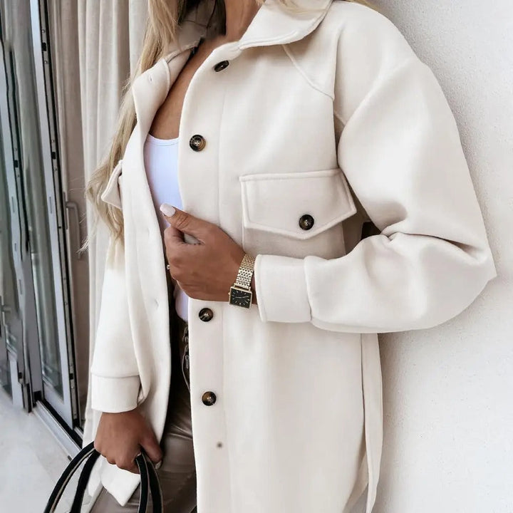 Close-up of a women's chic oversized jacket, showing soft wool blend texture and button detail