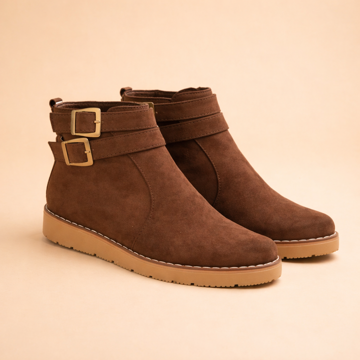 Stylish women's brown ankle boots featuring double buckles & a sturdy textured sole for fall/winter outfits.