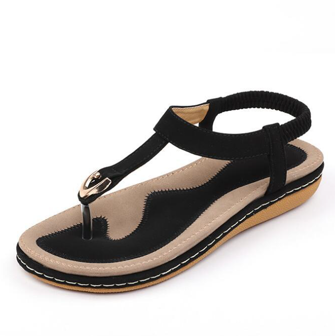 A woman wearing comfortable T-strap sandals with cushioned footbed and elastic back for secure fit.