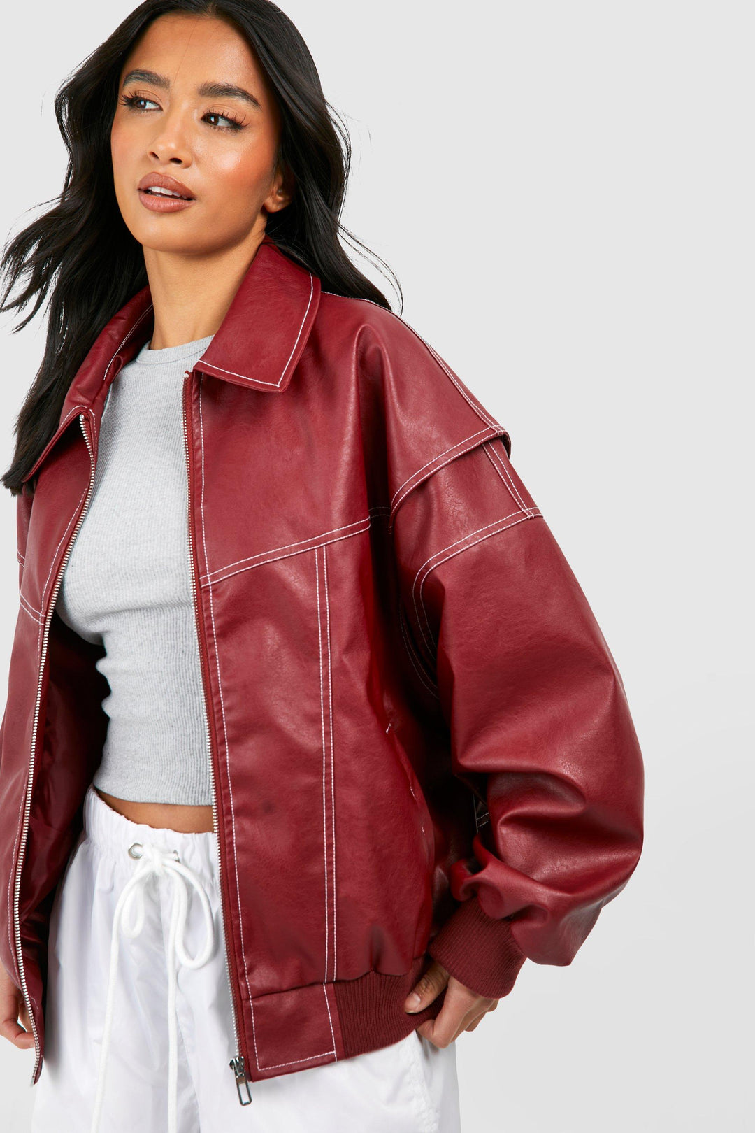 Stylish woman in a black faux leather bomber jacket, side view, perfect for spring