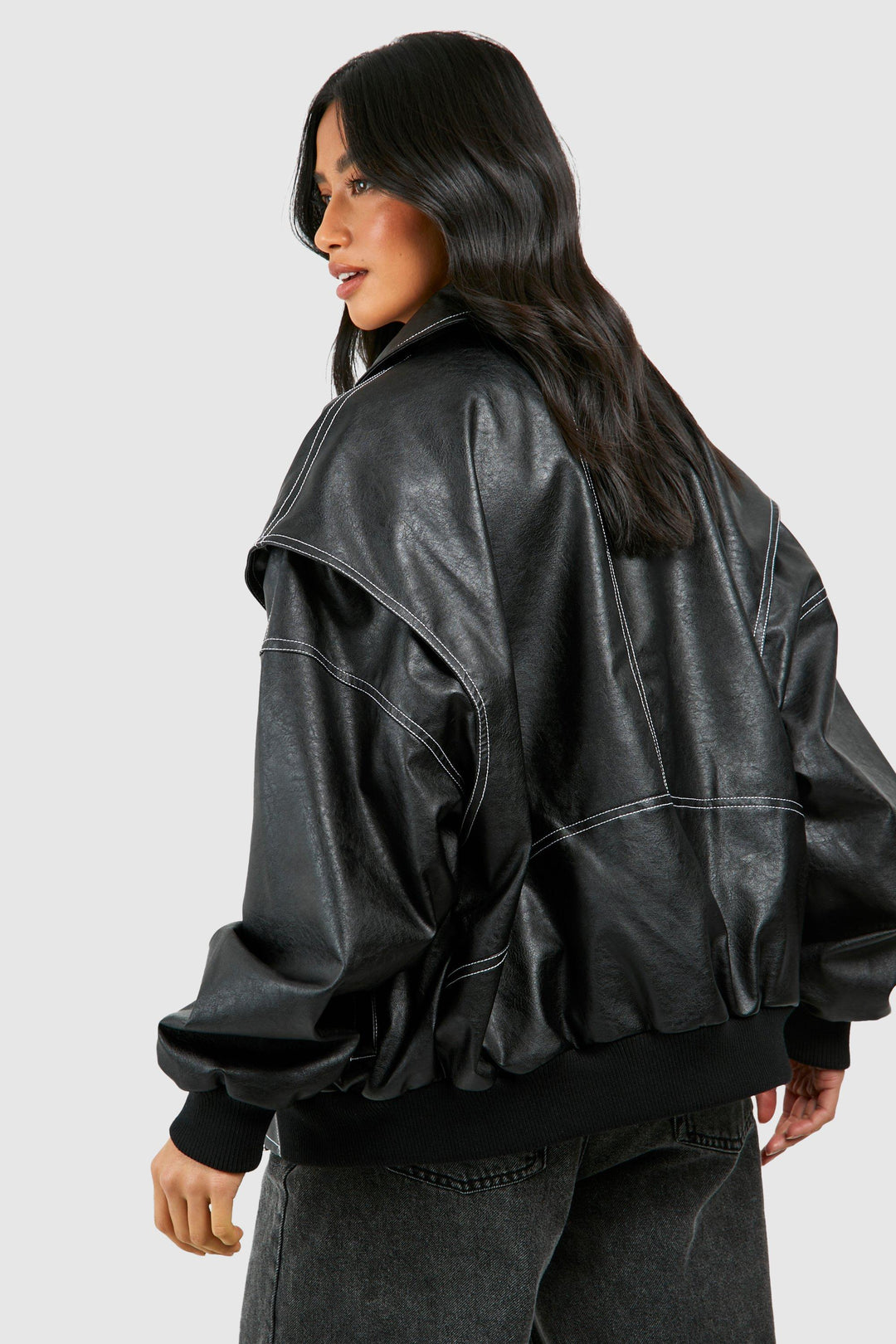 Full-body shot of a woman in a black faux leather bomber jacket, ideal for layering