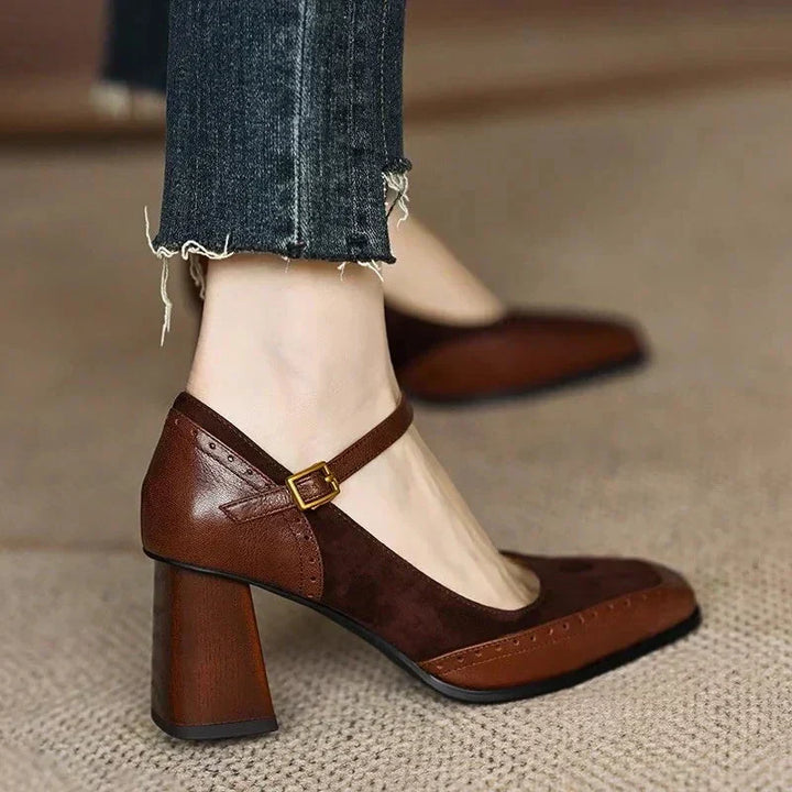Women's classic black leather pump with ankle strap, low heel, square toe, and brogue detail for office wear.