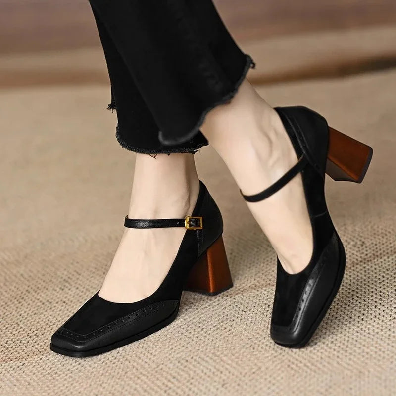 Black leather formal pumps for women, complete with an ankle strap, square toe, low heel, and brogue.
