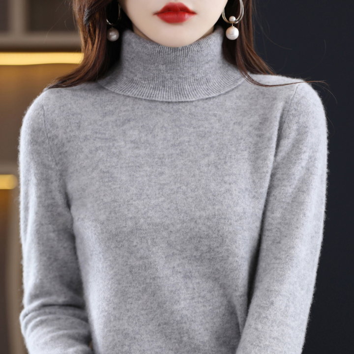Stacked pile of various colored women's knit turtleneck sweaters, winter apparel