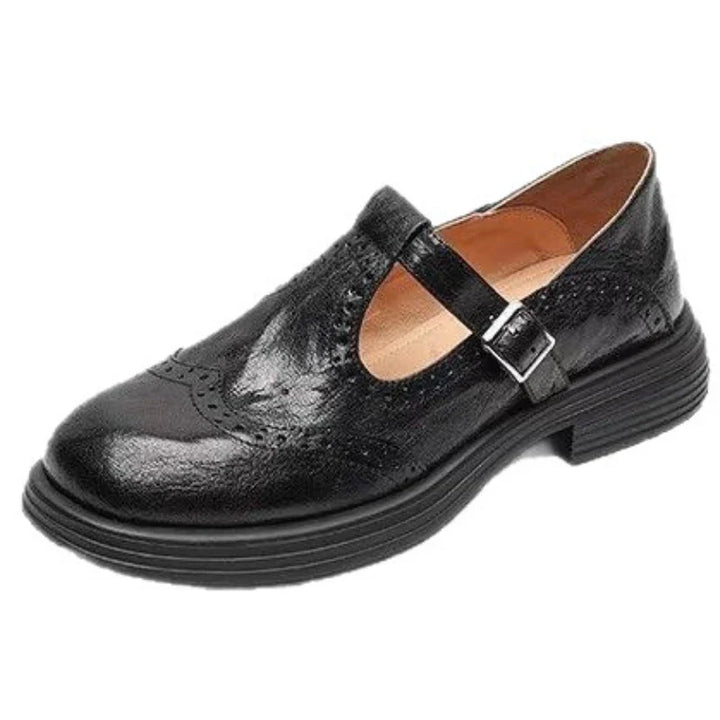 Close-up of women's leather T-strap flat shoes in a neutral tan, showcasing classic design and quality