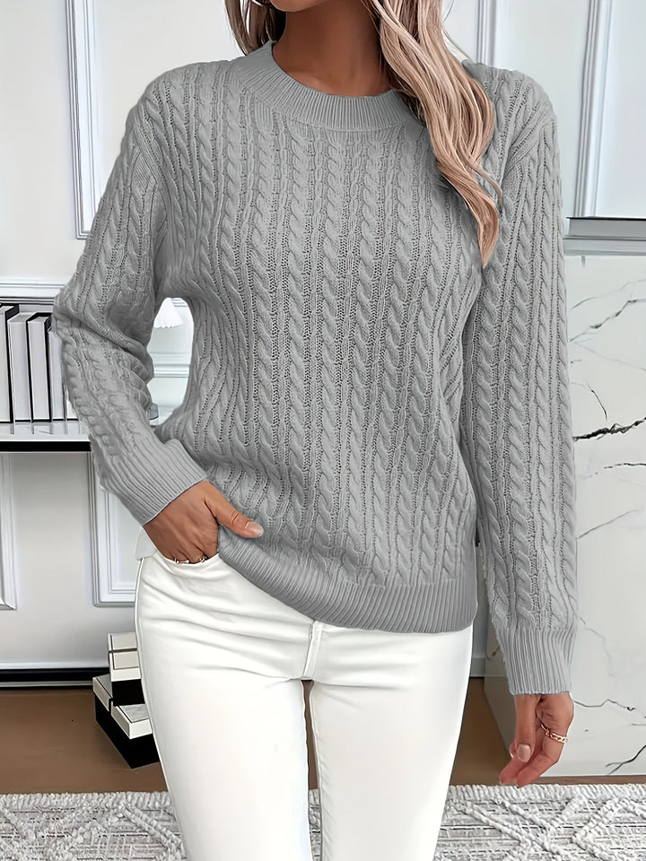 Front view of a women's knitted top, featuring a timeless cable knit design and relaxed fit.
