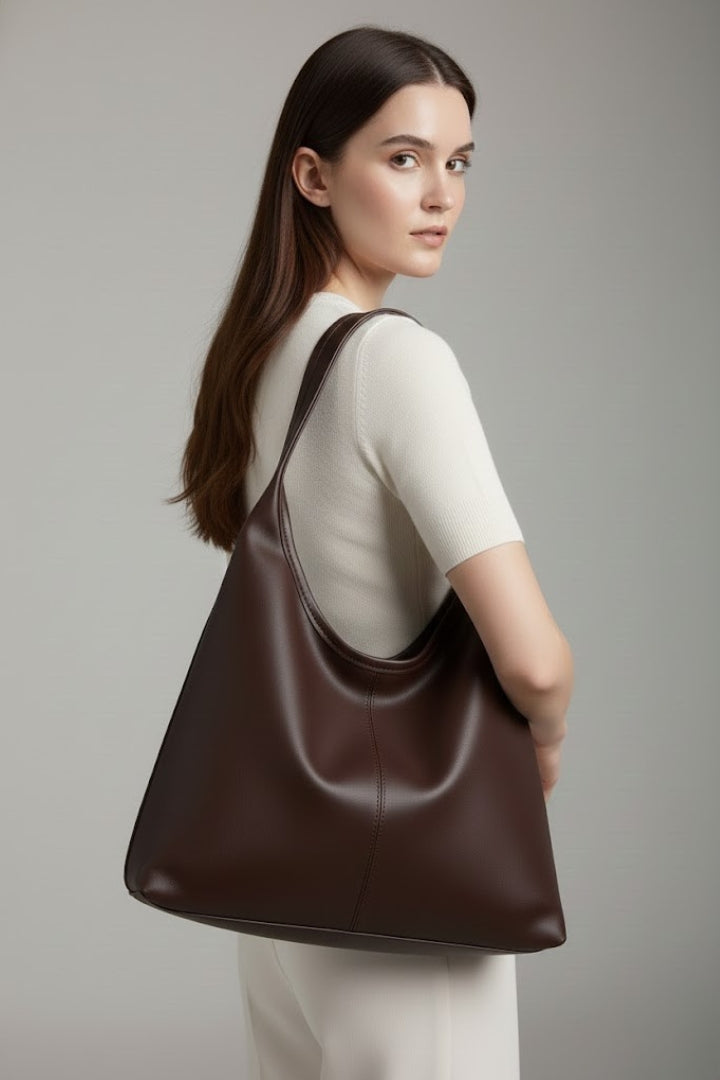 Stylish woman carrying a classic faux leather tote bag on her shoulder, perfect for work or daily errands.