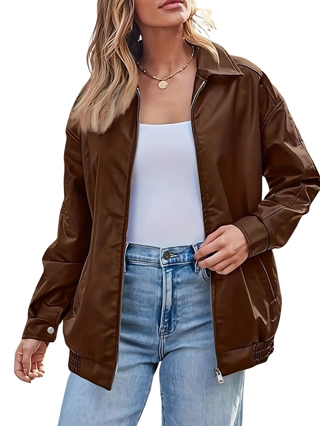Detailed shot of zipper and ribbed cuffs on a women's black faux leather bomber jacket