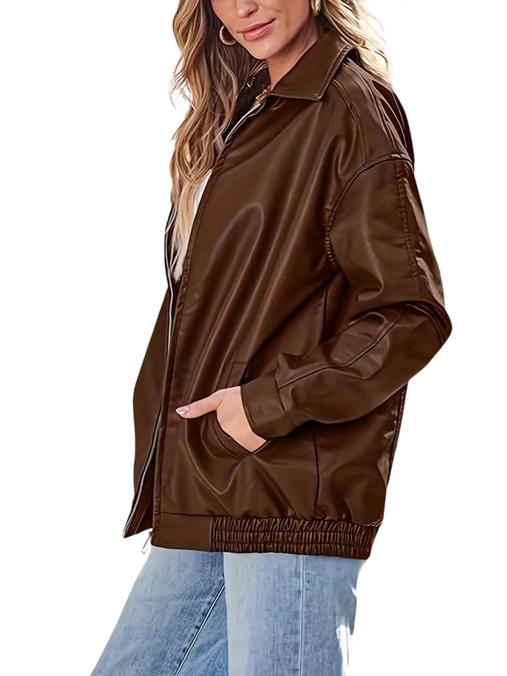 Fashionable women's oversized leather bomber jacket paired with jeans, a versatile fashion statement