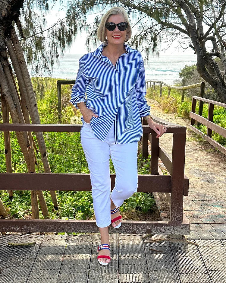 Close-up of a women's striped button-up shirt in pink, highlighting the fabric texture and details