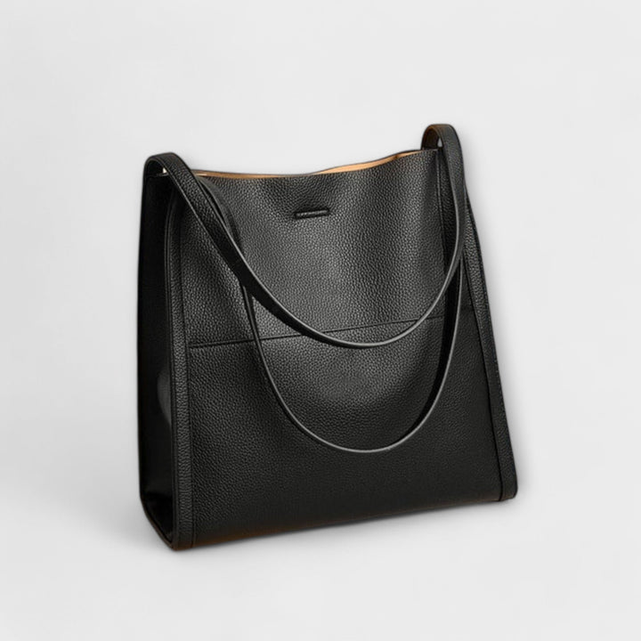 Women's classic structured shoulder bag paired with an evening dress, a stylish elegant bag.